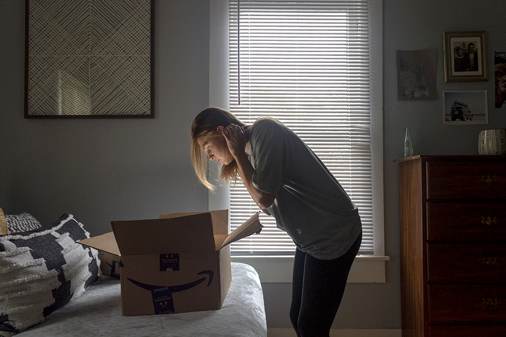 A photograph of a girl looking into a cardboard box