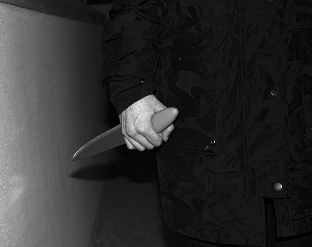 A photograph of a person holding a large knife