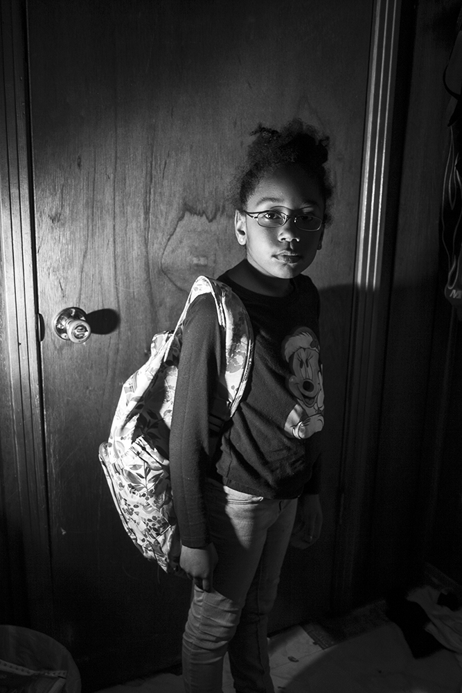A photograph of a young girl with her backpack on 