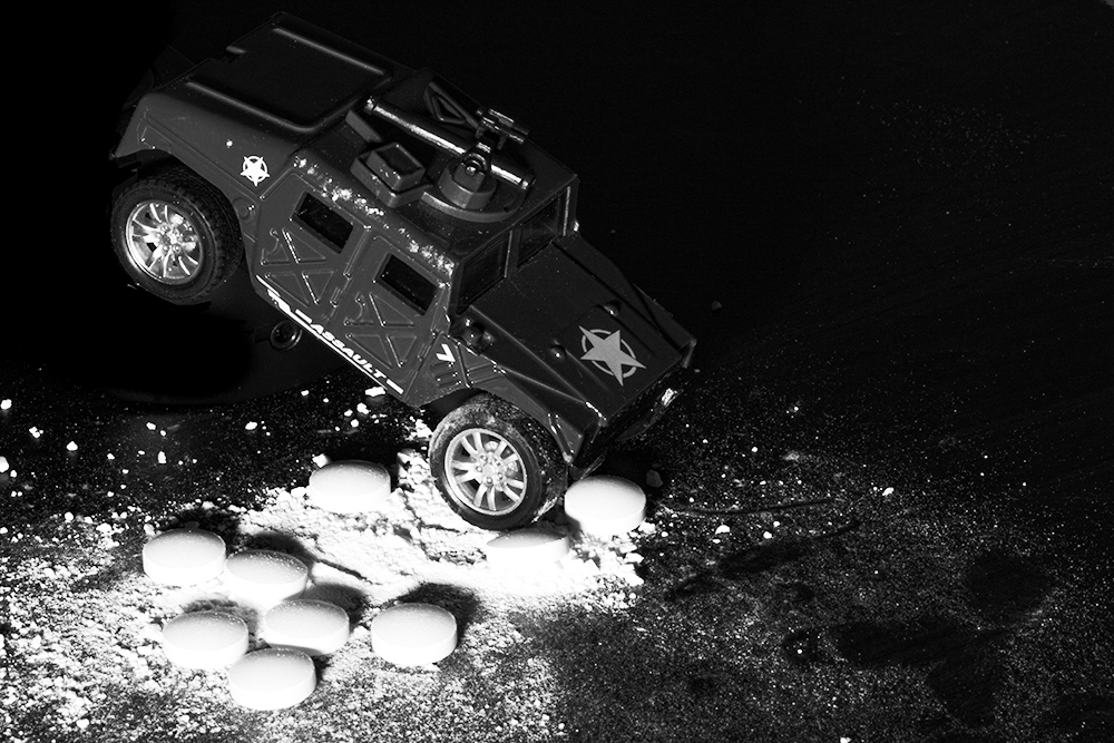 A photograph of a toy car crushing pill like figures. 