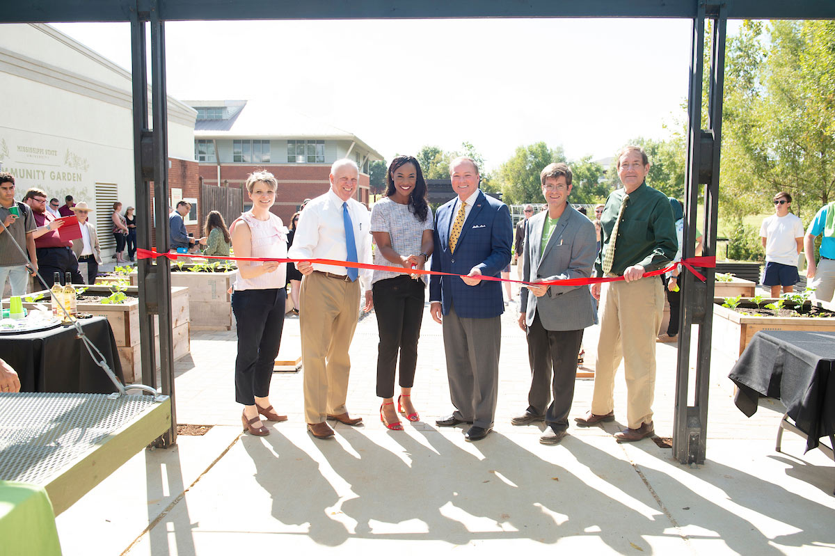 Cutting a ribbon at a ceremony on Oct. 15, 2018 at the MSU Community Garden are (l-r) Dean Angi Elsea Bourgeois; Dean George Hopper; Student Association President Mayah Emerson (cutting ribbon); MSU President Mark E. Keenum; Associate Professor Cory Gallo; and Vice President for Agriculture, Forestry and Veterinary Medicine Gregory Bohach. (photo by Megan Bean)