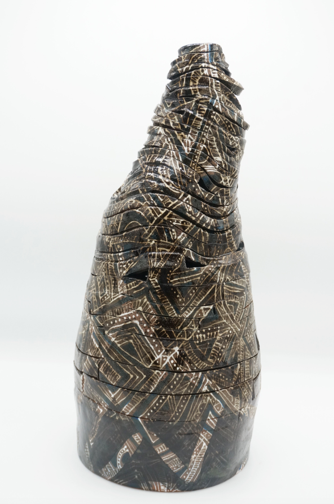 Cone shaped ceramic sculpture in the form of spiraling ribbon patterned with brown motifs