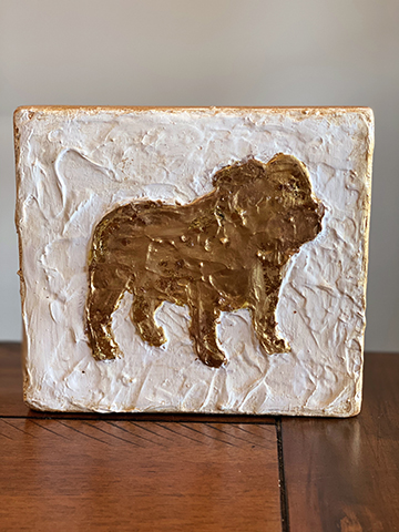 Photograph of a painted block with a brown bulldog on white background.