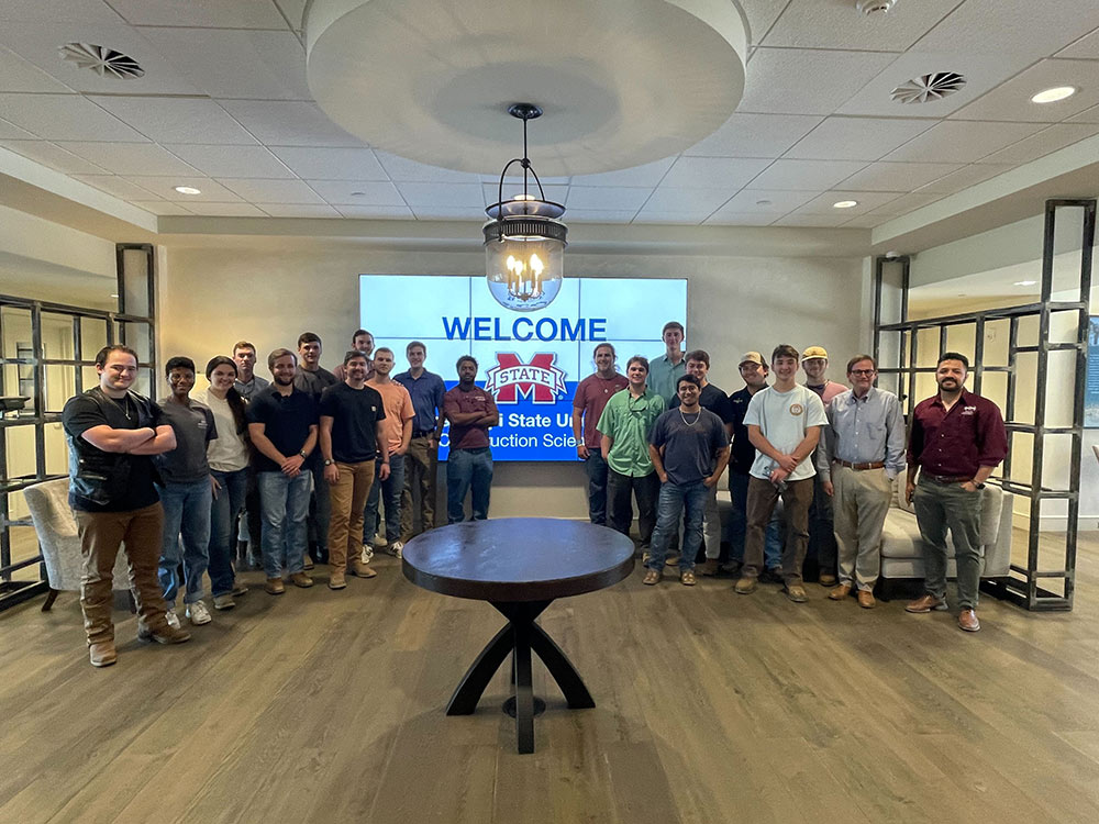 group of MSU building construction science students in room in front of screen (two professors are at far right of group)