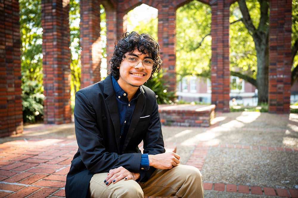 Jesus Morales sits outside on campus at Mississippi State University