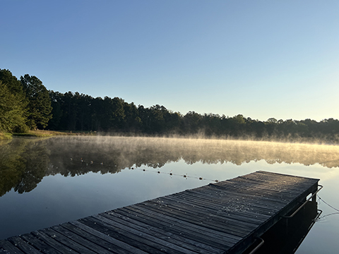 Photograph of a dock going into a lake.