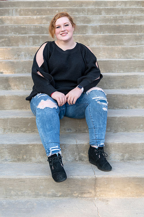 Hailey Nickels sits on steps