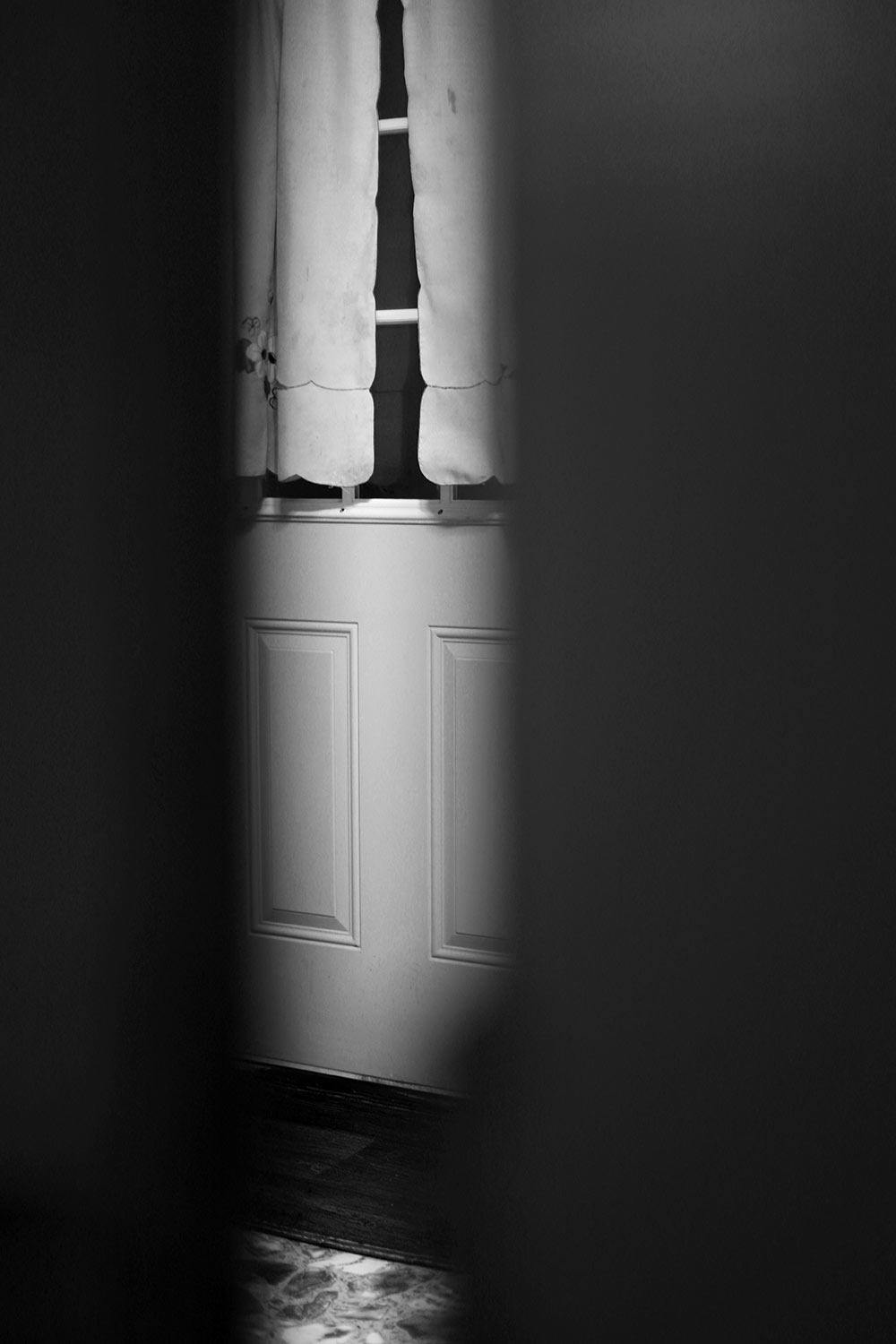 black and white photo by MSU photo student Maurissa Shumpert of door with curtain