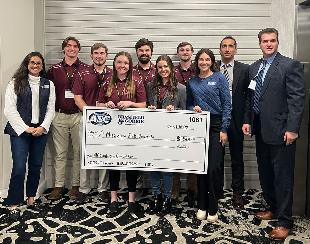group poses holding a big check: Pictured, left to right: A representative from Brasfield and Gorrie, Eric Cothern, William “Cameron” Crace, Kasey Losik, Jackson Drescher, Maurin Dooley, Nolan Grady, a representative from Brasfield and Gorrie, Visiting Assistant Professor Hamed Rafsanjani and Assistant Professor Afshin Hatami.