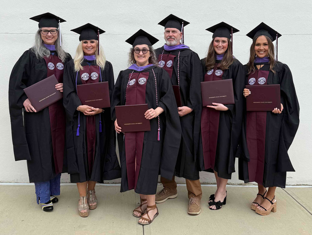 MFA in historic preservation grads pose in regalia at Mississippi State University May 2025 graduation