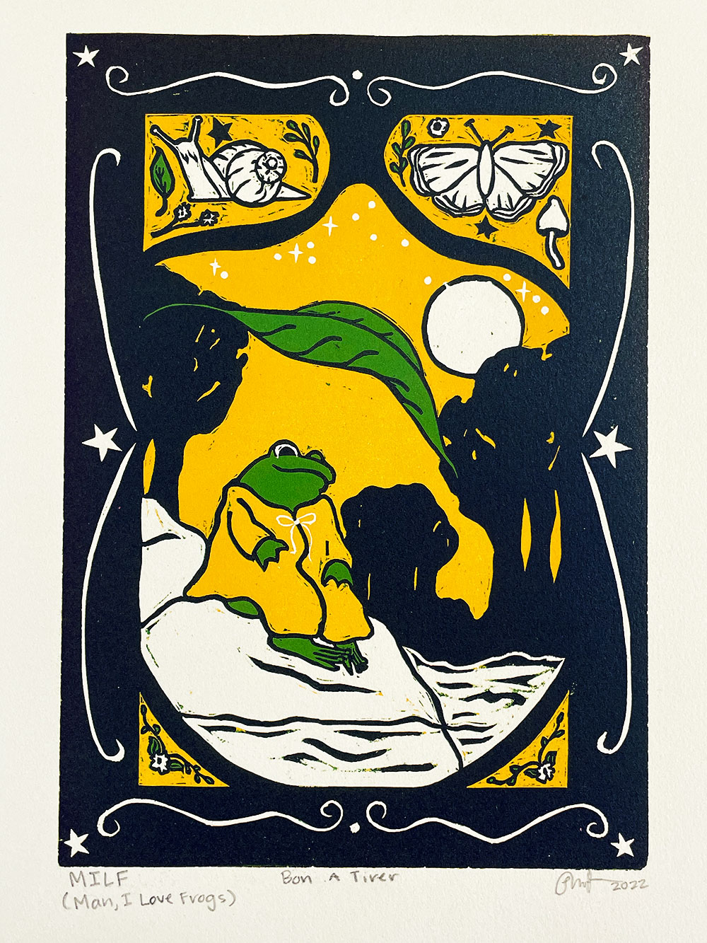 A printed image composed of cartoon frog resting on a rock surrounded by the sea, trees, a butterfly, and snail. Printed using the colors yellow, deep blue, and green.