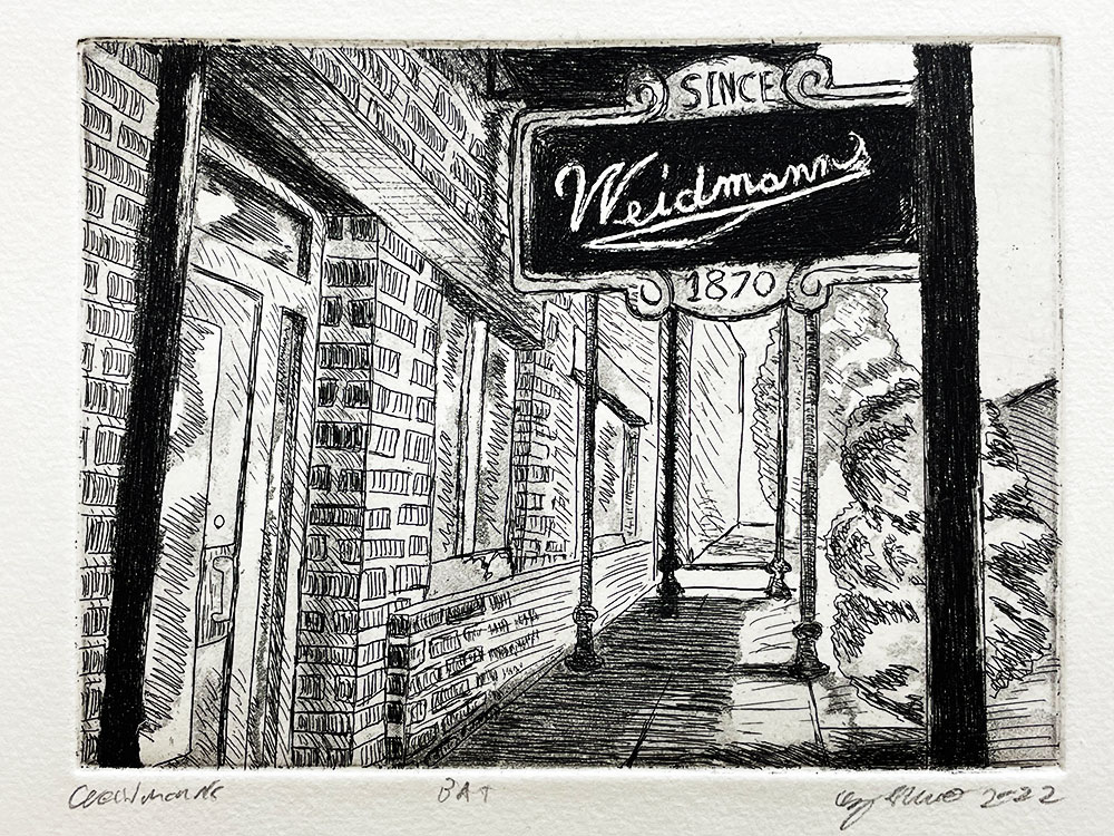 A black and white printed image composed of a street with brick building and glass windows. With a street sign that reads "Weidmann since 1870"