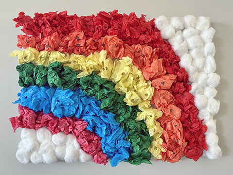 Sculpture of a rainbow made from tissue paper and cotton balls.