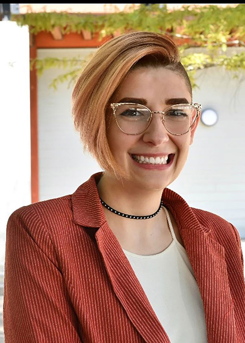 Ryann Cook headshot - wearing burnt orange suit jacket