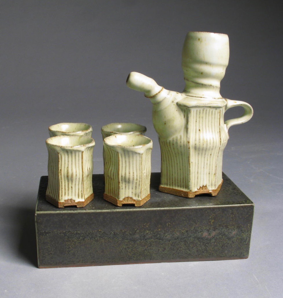 Tan sake set with four cups and pitcher.