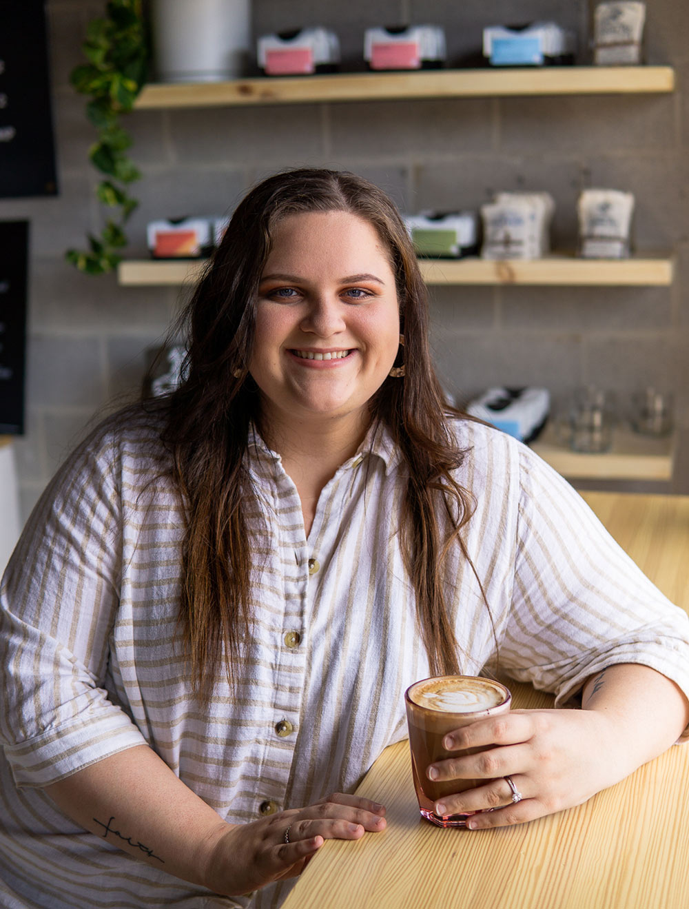 Samantha Wilson sits at table holding coffee