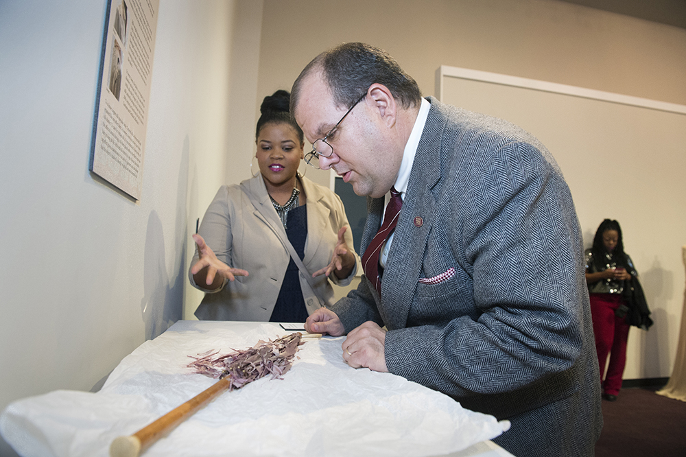 Junior human sciences/fashion design and merchandising major Fleshia D. Gillon of Amory and MSU School of Human Sciences Professor and Director Michael Newman examine a violet silk umbrella from the MSU Historic Costume and Textiles Collection. Part of the university's 