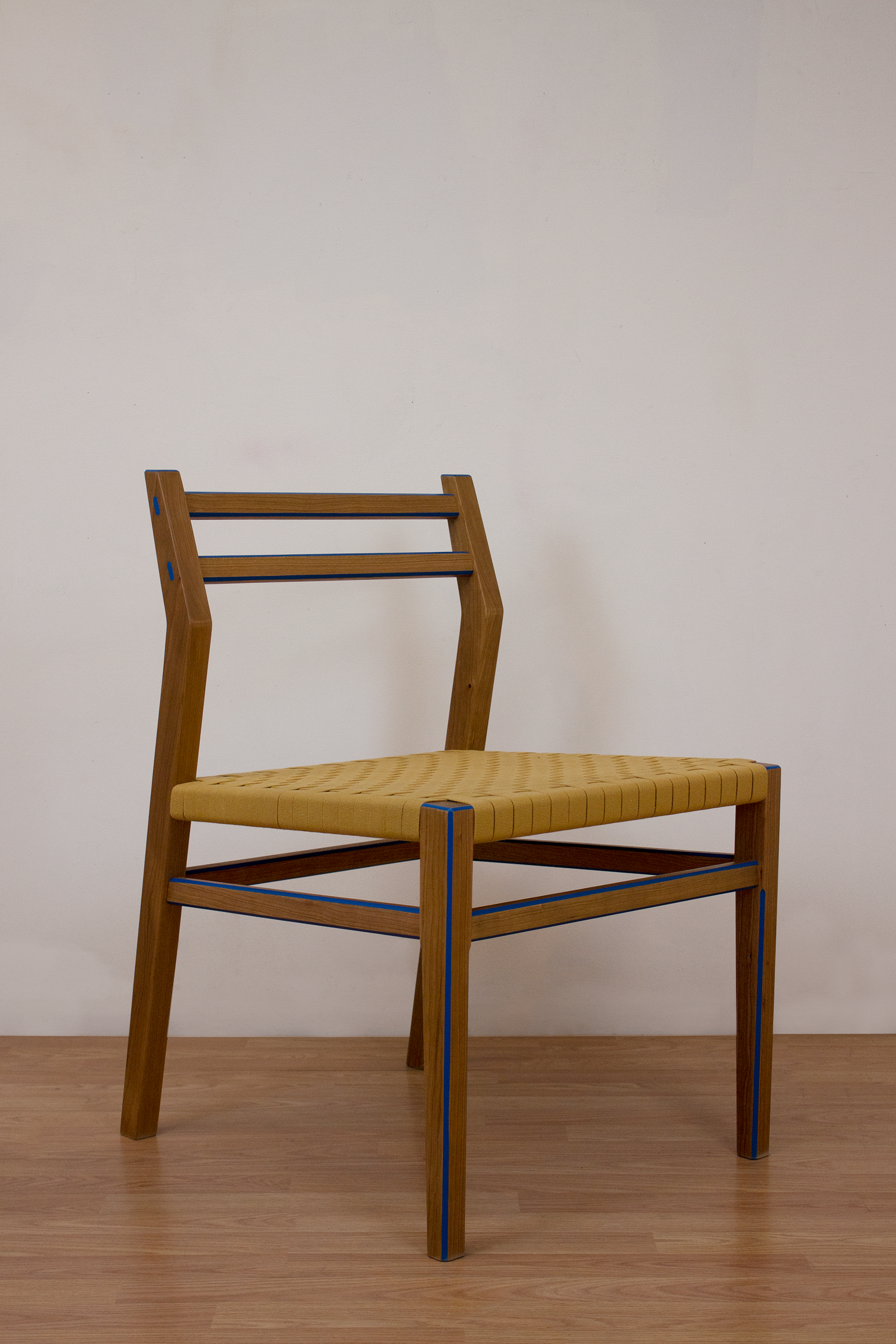 Side Cherry chair with woven Shaker tape seat and blue highlights on the edges