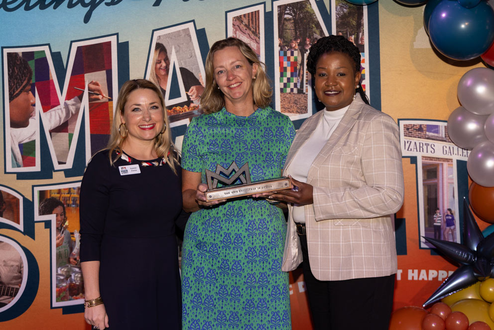 Mississippi State University Small Town Center Director Leah Kemp, center, stands with two other women holding an award.