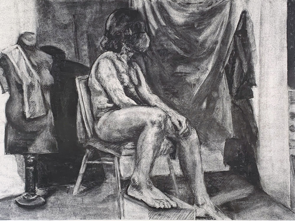 A charcoal drawing of a human model, using the reductive value technique to reveal light within the drawing. 