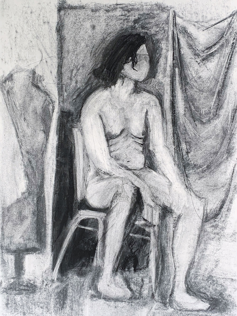 A charcoal drawing of a human model, using the reductive value technique to reveal light within the drawing. 