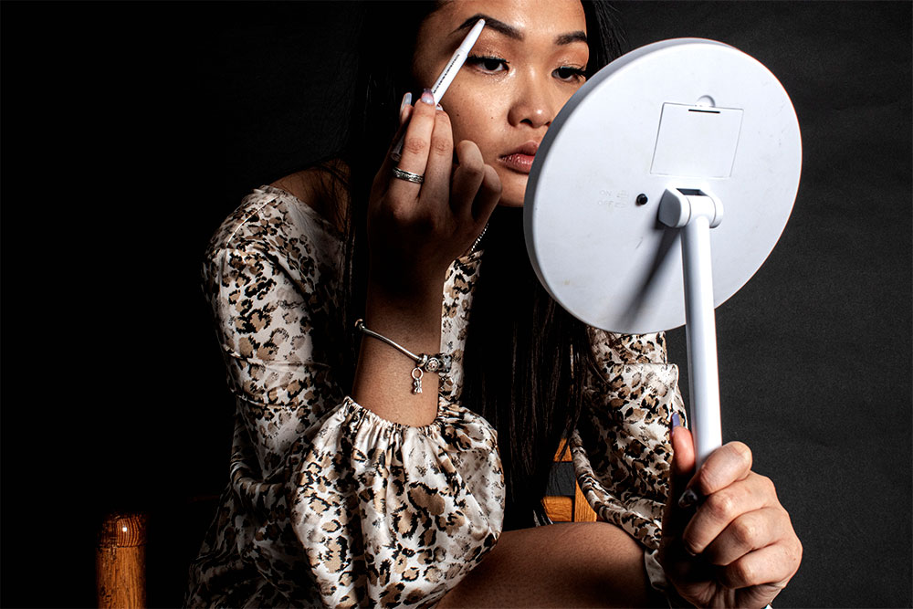 A photographed image of a girl applying makeup.
