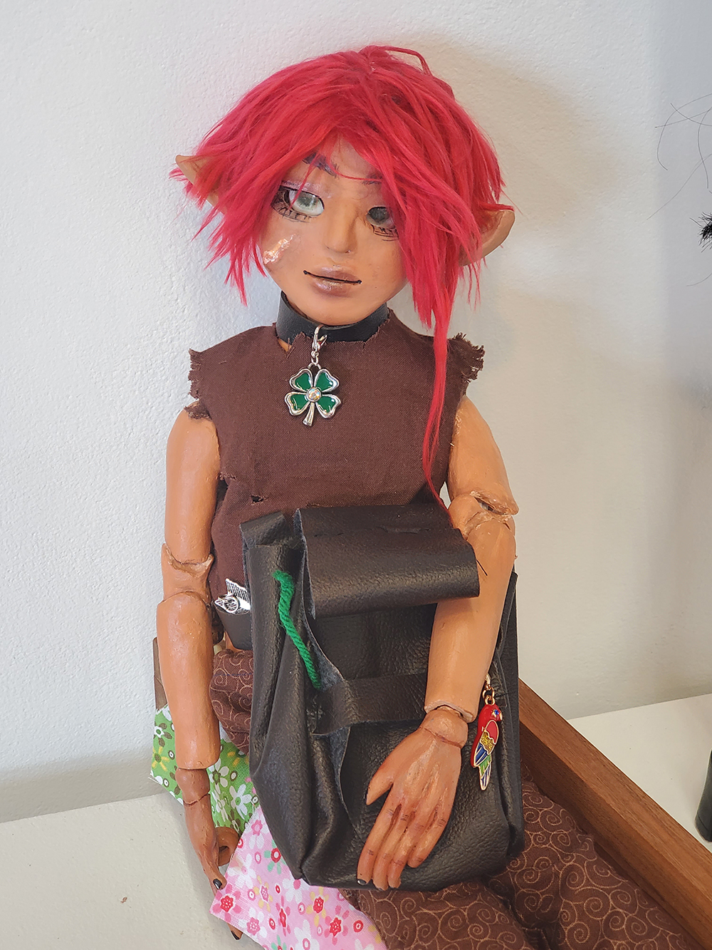 The elven doll is holding a pouch.