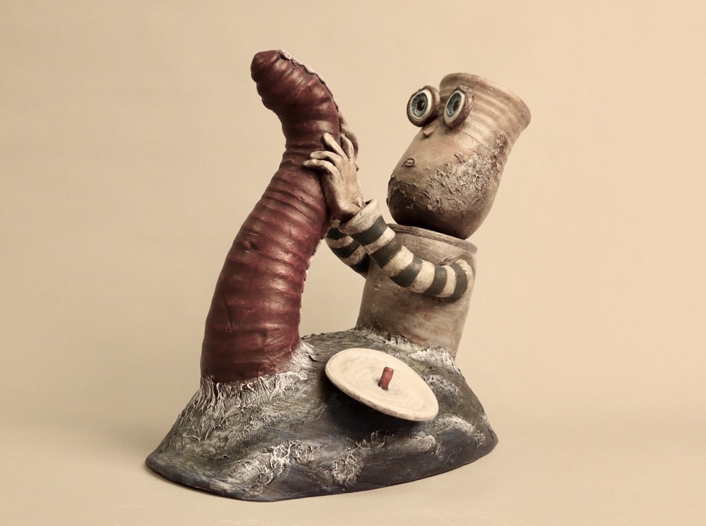 Ceramic french sailor wrestling a red tentacle in the swell of a wave