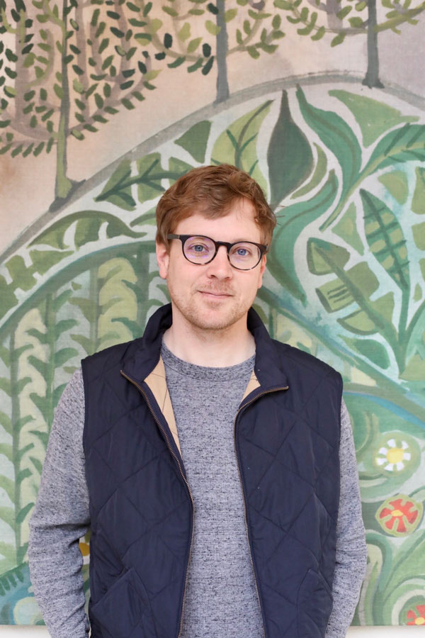 Adam Trest pictured in front of a mural.