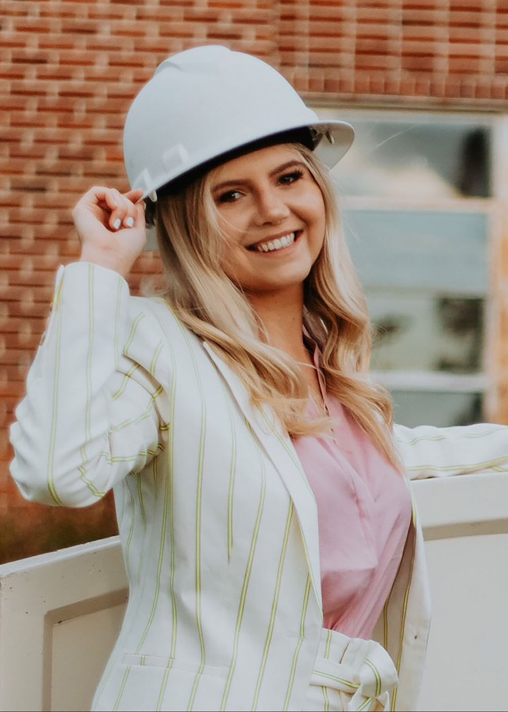 Blaise Booker holds hard hat and poses