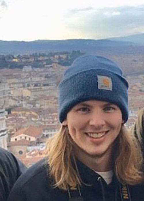 Trey Box headshot - wearing a blue ski hat with scenery in the background
