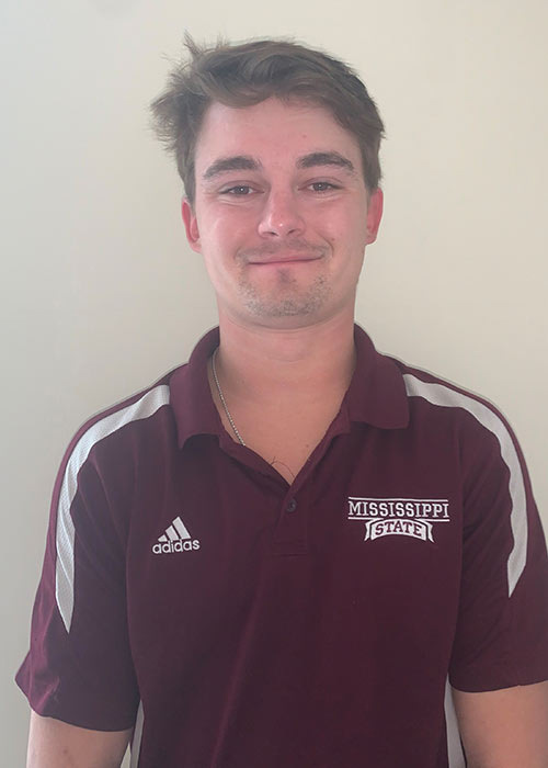 Chip Goza headshot - white wall in background - wears maroon polo - Adidas and Mississippi State logos in white