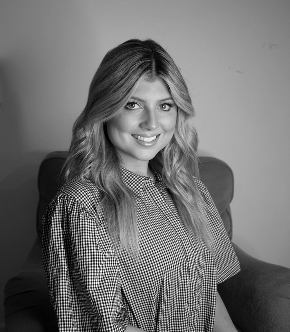 black and white headshot of Jenna Porter - sitting in chair