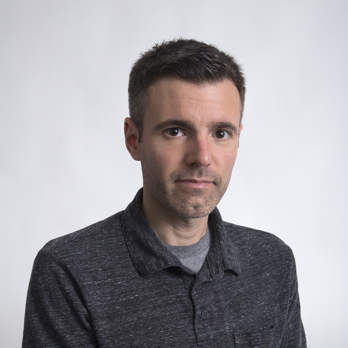 headshot of Dominic Lippillo wearing gray shirt with sold, light background