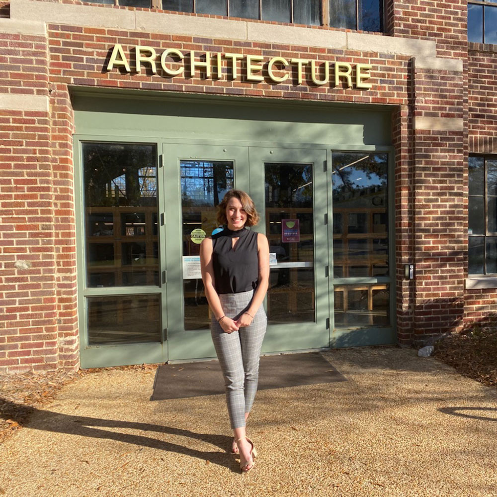 Elle Mason stands in front of the entrance to Giles Hall. "architecture is written on top of the building"