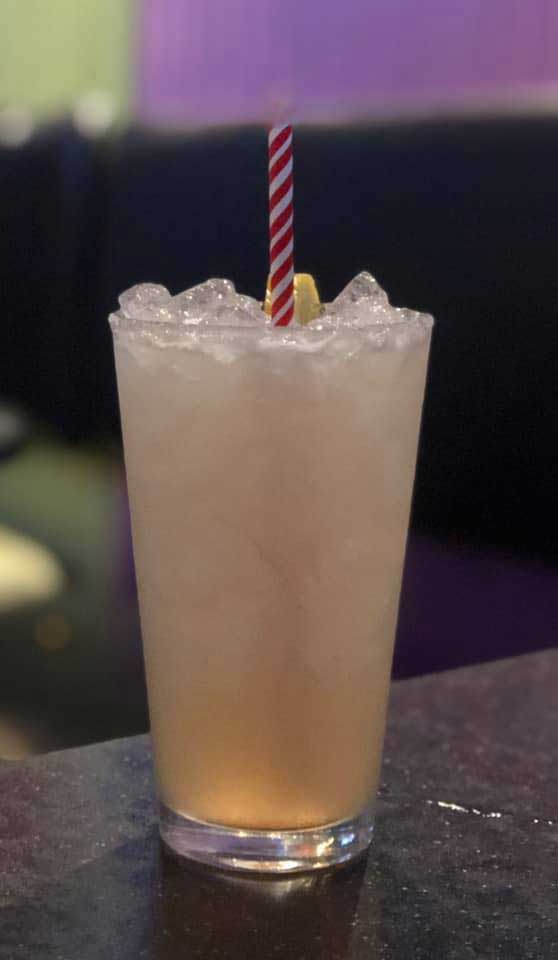 light pink/orange drink with a paper straw