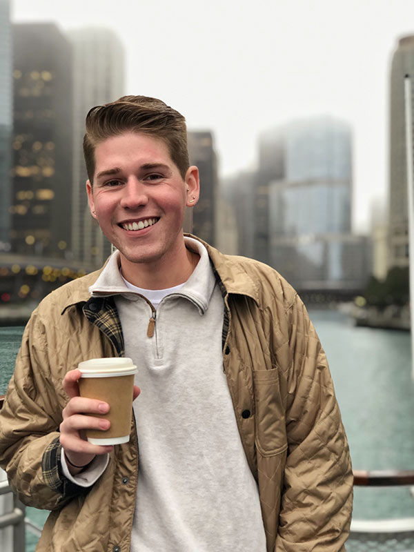 Cary Reynolds poses in front of water holding drink