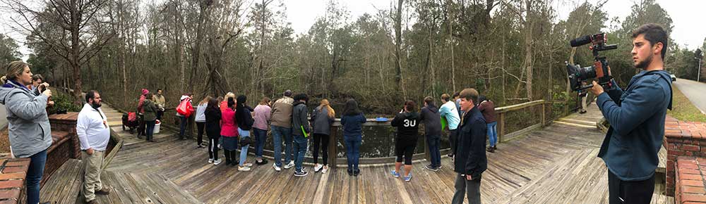 WHHS students in Florence Gardens. students shown gathered on deck by rail looking away from the camera into the water