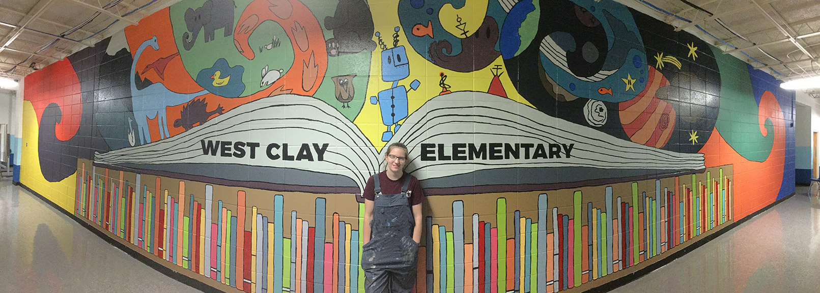 Lauryn Rody, Mississippi State University art major, stands in front of the mural she created for West Clay Elementary School