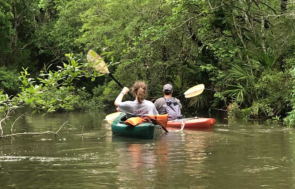 Pat Bonck in front kayak guides Hannah Davis on a tour of Turkey Creek 